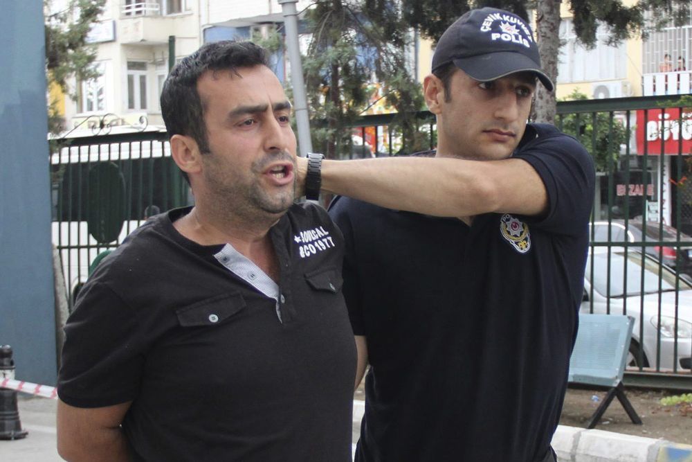 Un policía turco traslada a una comisaría a un soldado detenido por su supuesta partipación en el intento de golpe de Estado, en Mersin.