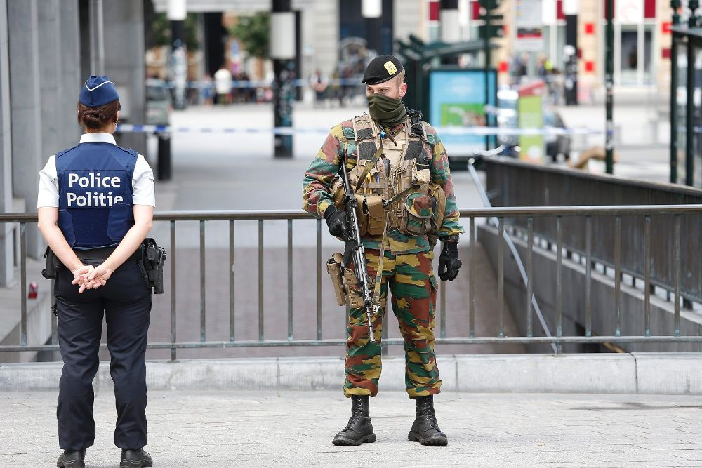 Un militar y un policía hacen guardia junto a la estación central del metro de Bruselas, evacuado por un posible atentado.