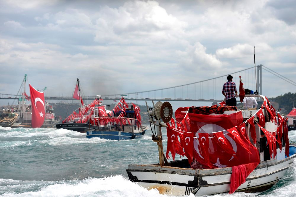 Varias personas en barcos sobre el Bósforo izan la bandera turca en señal de repulsa al golpe de Estado fallido.