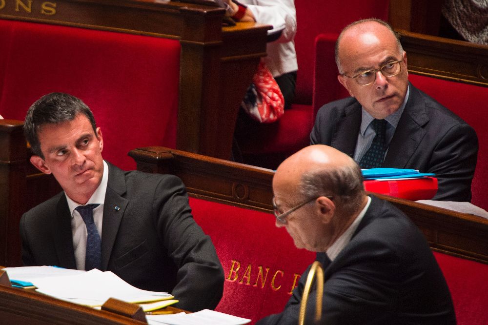 El primer ministro francés, Manuel Valls (i), y el ministro de Interior francés, Bernard Caseneuve (d), durante la sesión semanal de preguntas al gobierno.