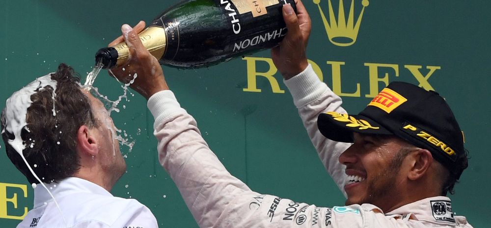Lewis Hamilton (R) celebra su victoria en el podium.