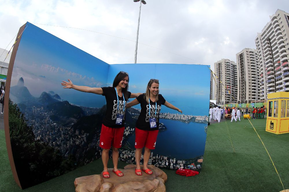Dos atletas canadienses posan junto a una imagen de la ciudad en la Villa Olímpica en Río de Janeiro.