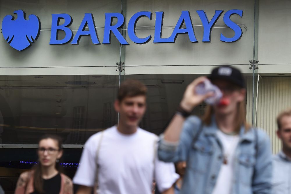Varios peatones transitan por delante de una sucursal del banco Barclays en Londres.