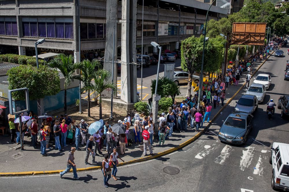 Personas haciendo fila para entrar en un supermercado en Caracas el pasado miércoles.