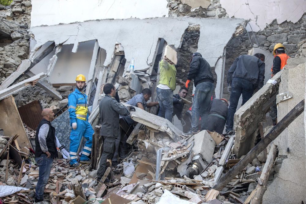 Miembros de los servicios de emergencia buscan personas atrapadas bajo una casa derrumbada a causa del terremoto en Fonte del Campo, cerca de Accumoli, en el centro de Italia.