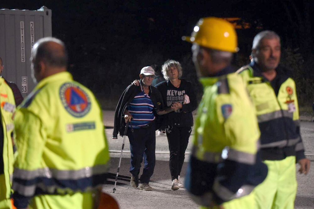 Voluntarios y afectados por el terremoto que golpeó Italia central se preparan para pasar su primera noche en un albergue temporal en Pescara del Tronto.