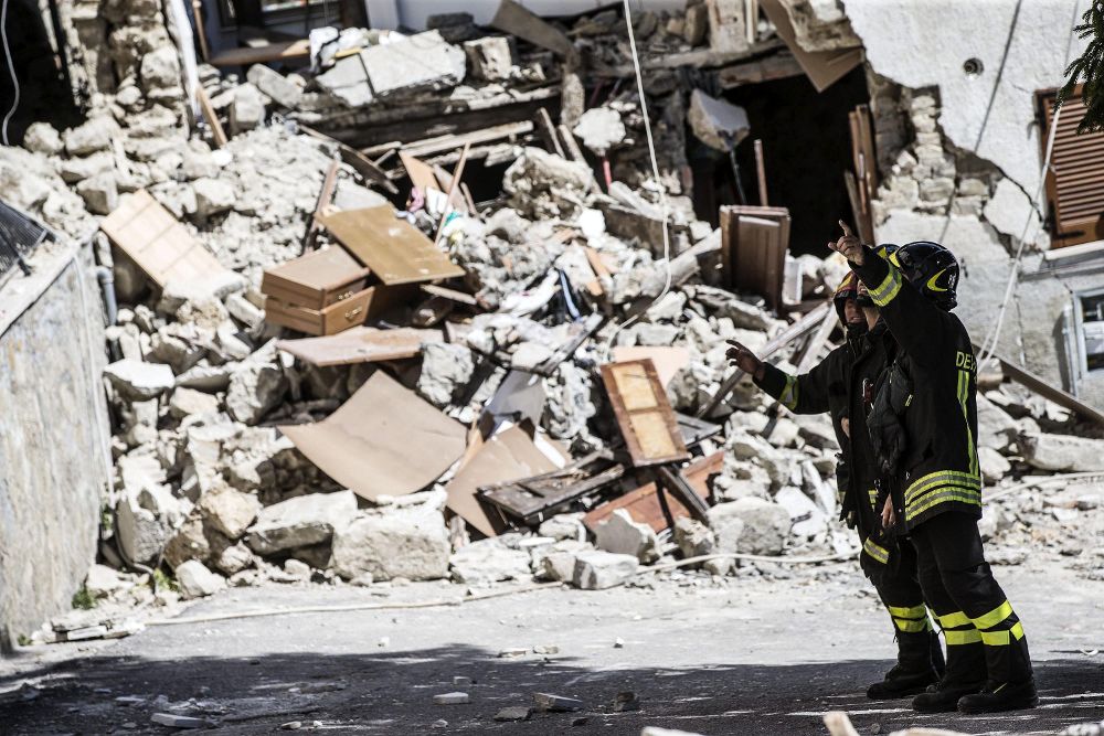 Varios bomberos trabajan entre los escombros en Arquata, centro de Italia.