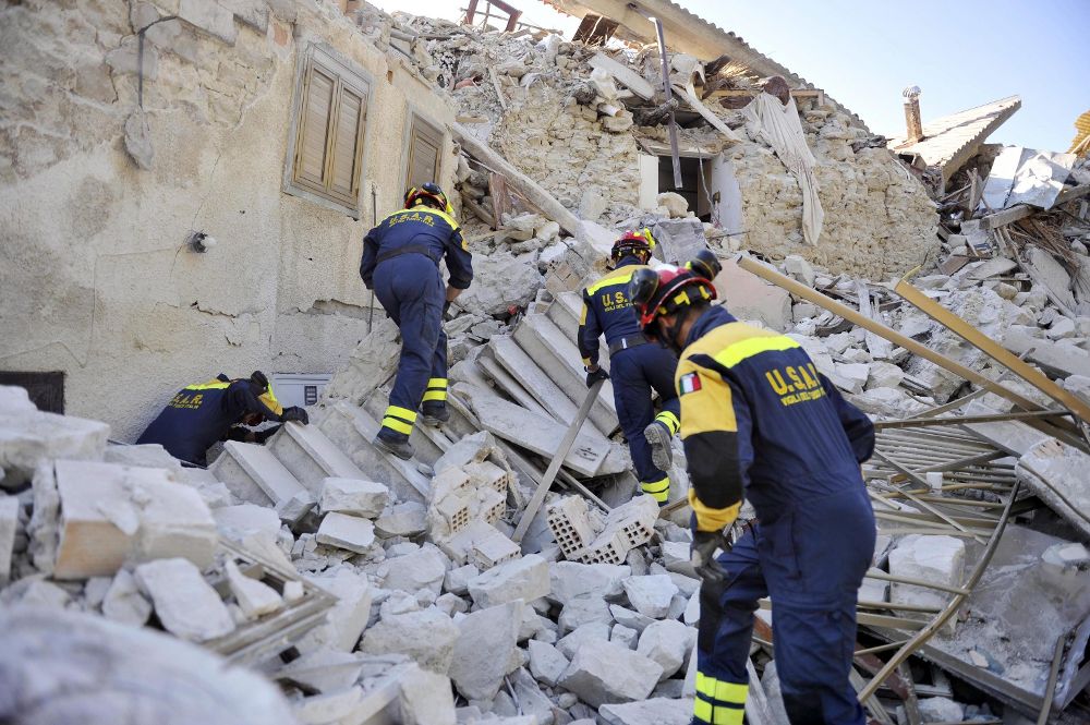 Varios bomberos trabajan entre los escombros en Pescara del Tronto, en la región de Marche, en el centro de Italia.
