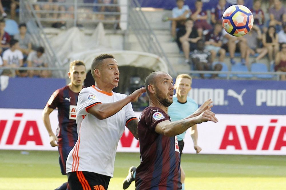 El delantero del Valencia Rodrigo Moreno (i) disputa un balón con el defensa del Eibar Iván Ramis (d).
