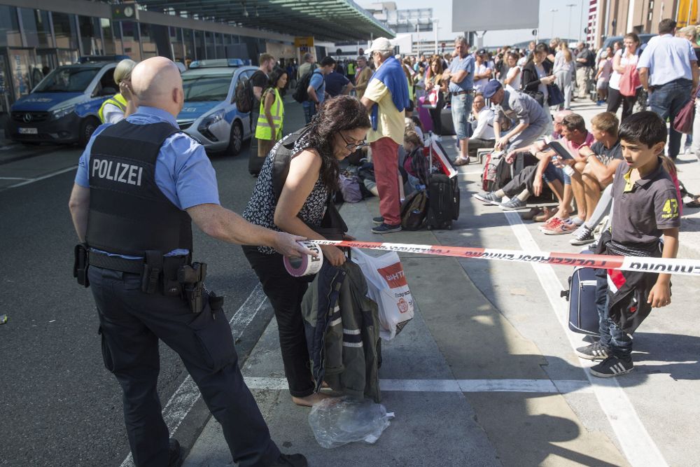 Un policía alemán acordona la zona a las afueras del aeropuerto de Fráncfort, en Fráncfort (Alemania).