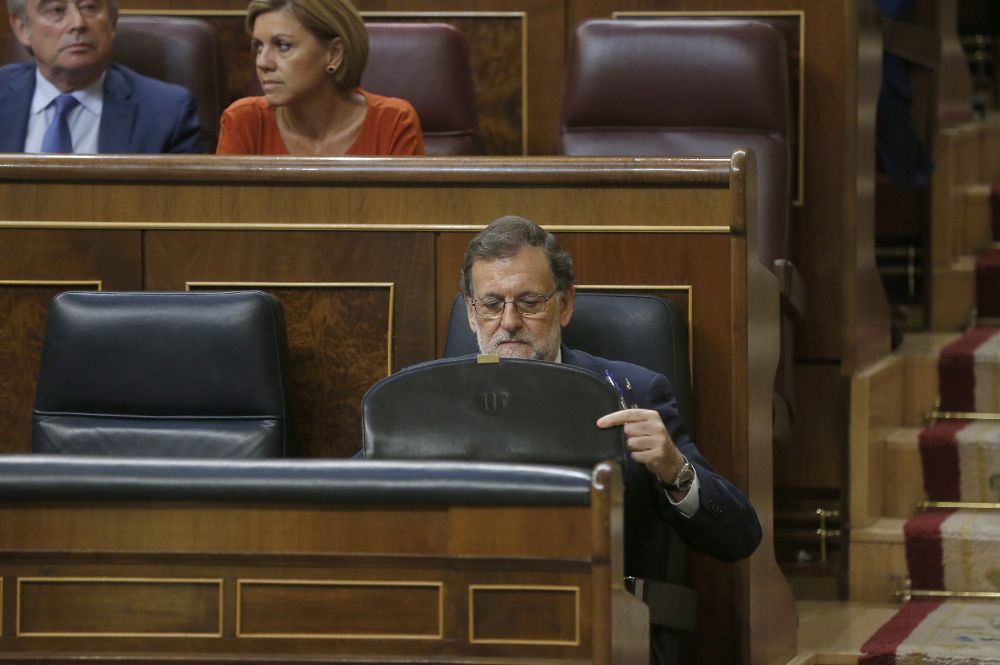 El presidente del Gobierno en funciones, Mariano Rajoy, recoge sus papeles en su escaño del Congreso esta tarde.