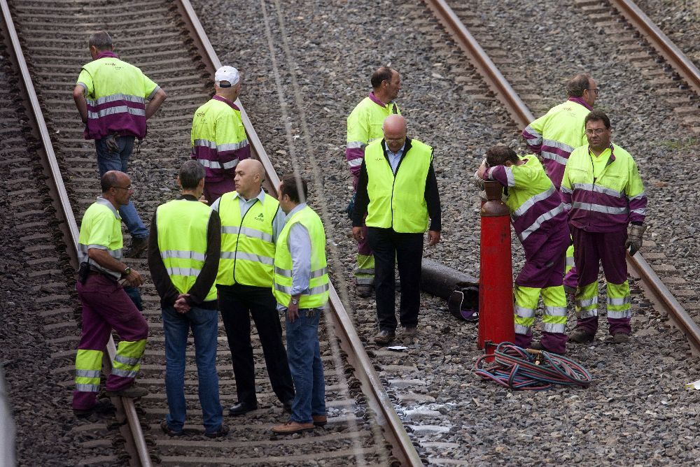Varios operarios después de trabajar toda la noche en la retirada del tren de la compañía Comboios de Portugal.