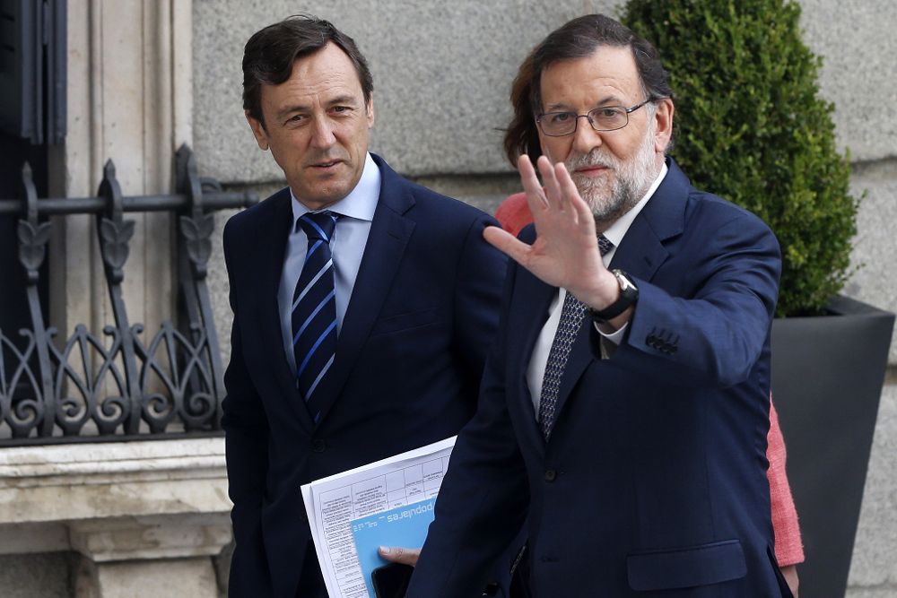 El jefe del Gobierno en funciones, Mariano Rajoy, saluda junto al portavoz, Rafael Hernando, a su llegada esta mañana al Congreso.