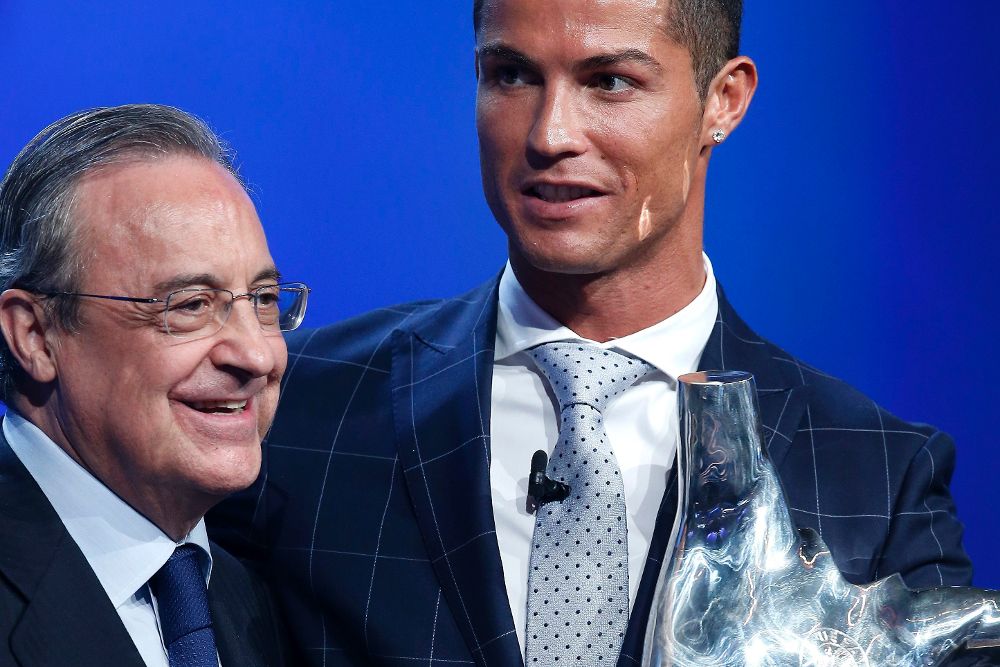 El delantero del Real Madrid Cristiano Ronaldo (d) con el trofeo que le acredita como el mejor jugador de la UEFA en la temporada 2015-16 junto con el presidente del equipo blanco, Florentino Pérez (i).