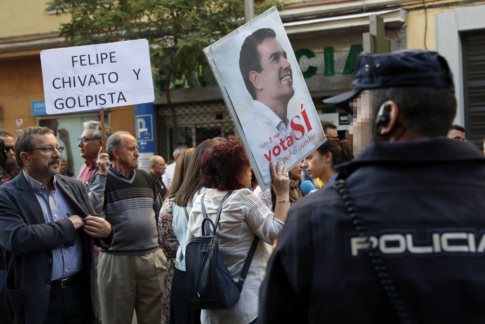 Dos simpatizantes de Pedro Sánchez muestran pancartas a las puertas de la sede del PSOE, en la madrileña calle Ferraz.