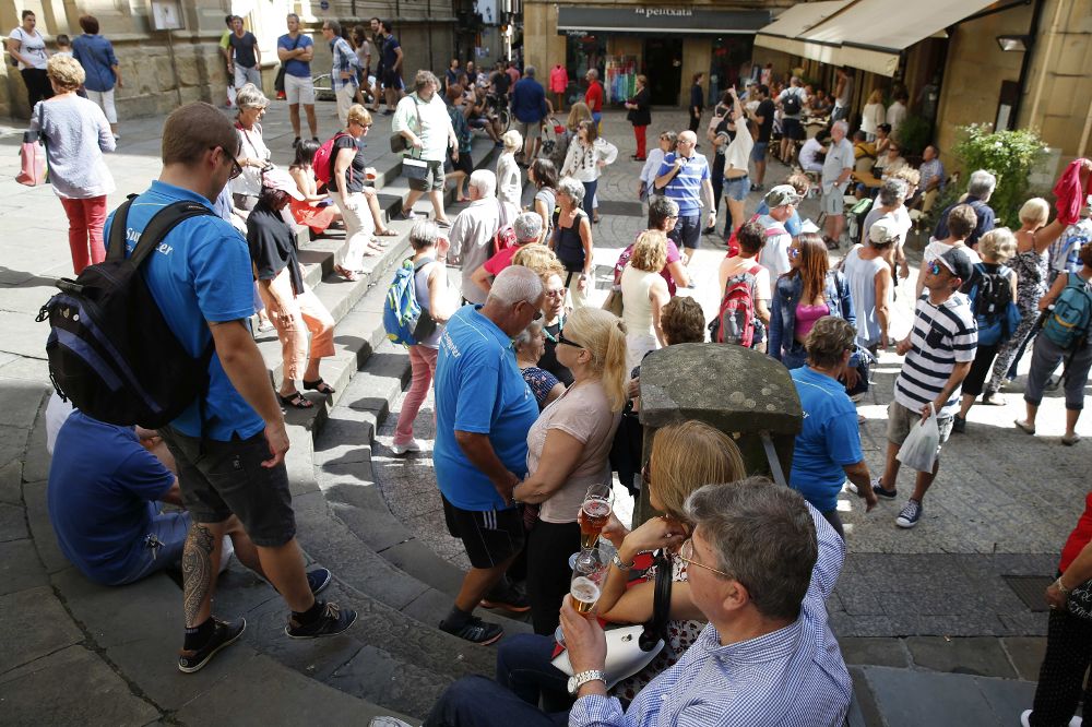 Unos turistas toman fotografías en la Parte Vieja donostiarra. El récord de visitantes que San Sebastián ha registrado este verano ha abierto en la ciudad el debate sobre la sostenibilidad del modelo turístico de la ciudad.