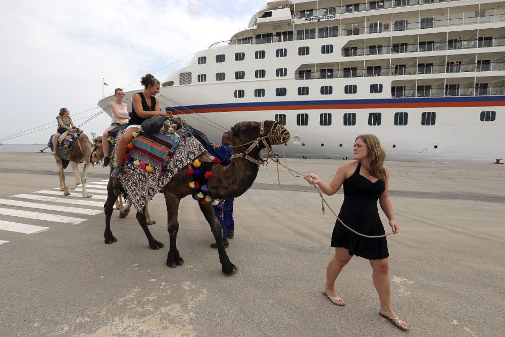 Turistas alemanas montan en camello después de que el crucero "EUROPA", de la compañía Hapag-Lloyd, haya atracado en el puerto de La Goleta, Túnez, hoy, 6 de octubre.