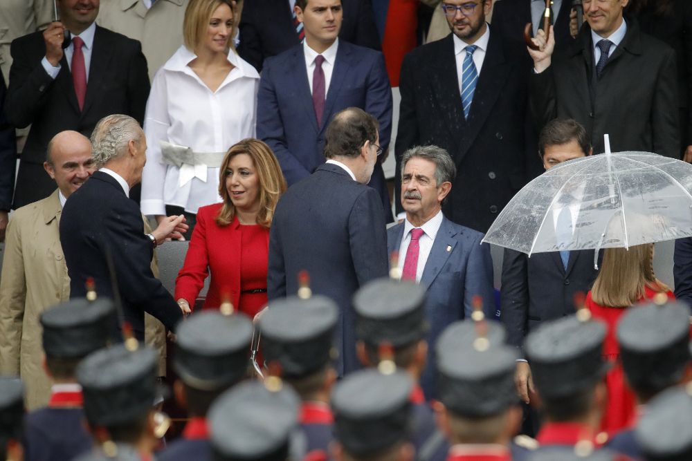 El presidente del Gobierno en funciones, Mariano Rajoy (c), saluda al presidente de Cantabria, Miguel Ángel Revilla, a su llegada al acto central del Día de la Fiesta Nacional.