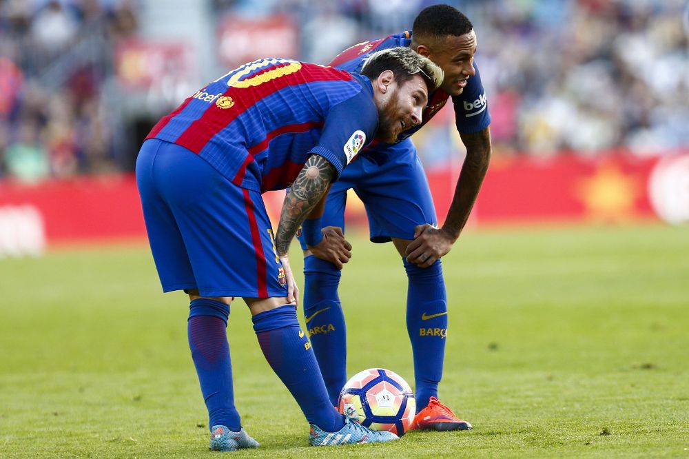 Leo Messi (i) y Neymar Da Silva se preparan para el lanzamiento de una falta durante el partido.