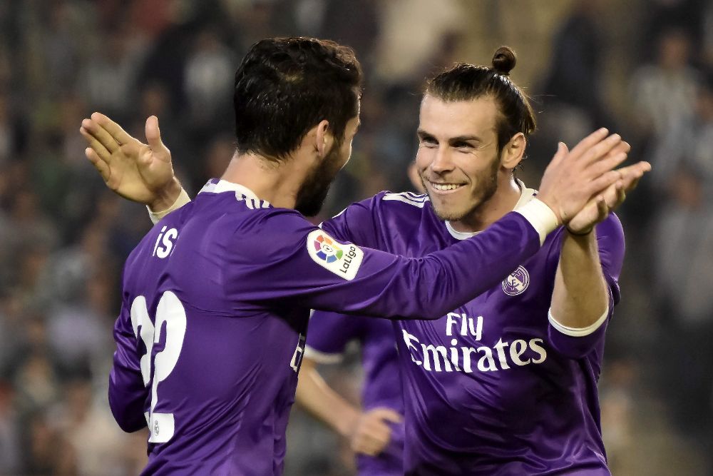 Los jugadores del Real Madrid, Isco (i) y el galés Gareth Bale, celebran el cuarto gol del equipo madridista, durante el encuentro correspondiente a la octava jornada de primera división, que disputan esta noche frente al Betis en el estadio Benito Villamarín de Sevilla.
