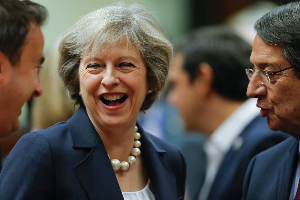 La primera ministra británica sonríe junto con el primer ministro luxemburgués Xavier Bettel (i) y su homólogo chipriota Nicos Anastasiades al comienzo de la cumbre de jefes de Estado.