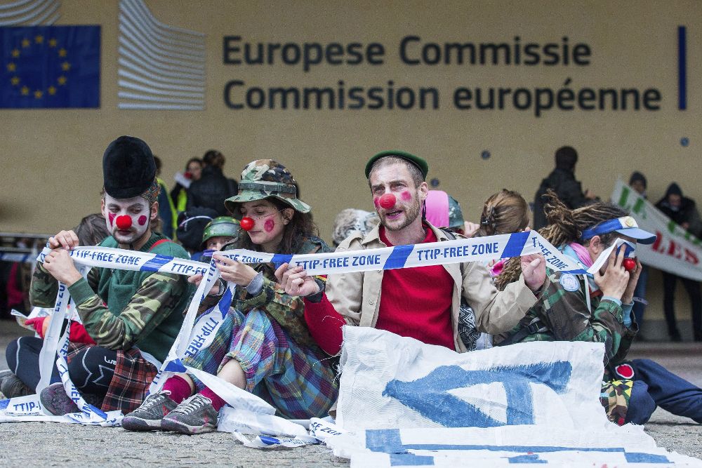 Manifestantes disfrazados de payaso participan en una protesta contra el el acuerdo de libre comercio entre la Unión Europea y Canadá (CETA), frente al edificio de la Comisión de la Unión Europea en Bruselas.