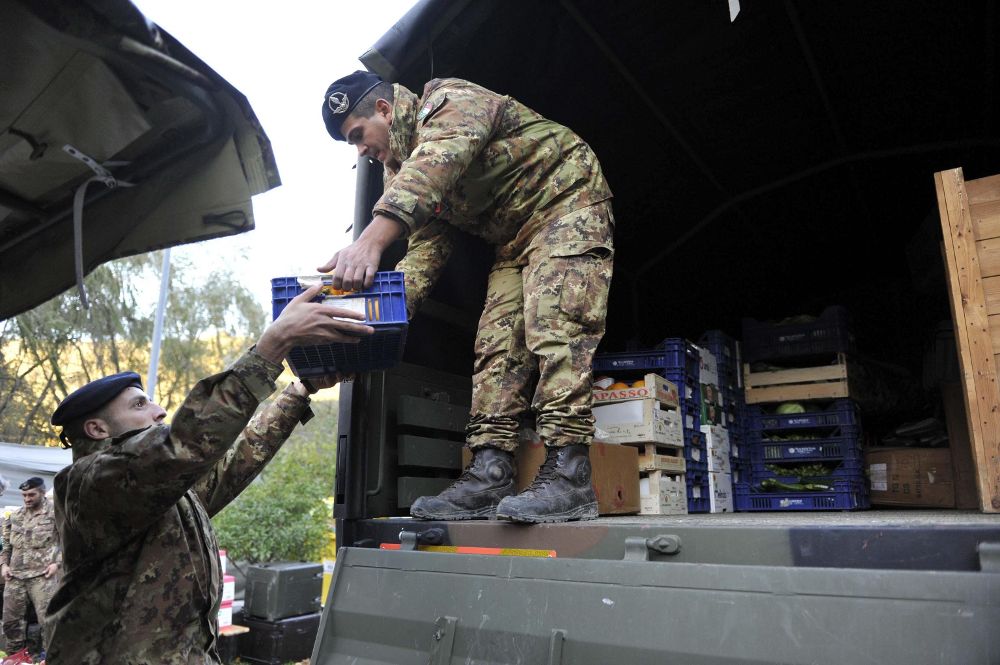 Soldados italianos cargan alimentos en un camión en un centro creado por Protección Civil para los afectados por el terremoto en Visso, Italia.