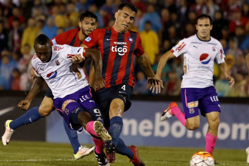 El jugador de Cerro Porteño de Paraguay Junior Alonso (c) disputa un balón con Fernando Caicedo (i) de Independiente Medellín de Colombia.