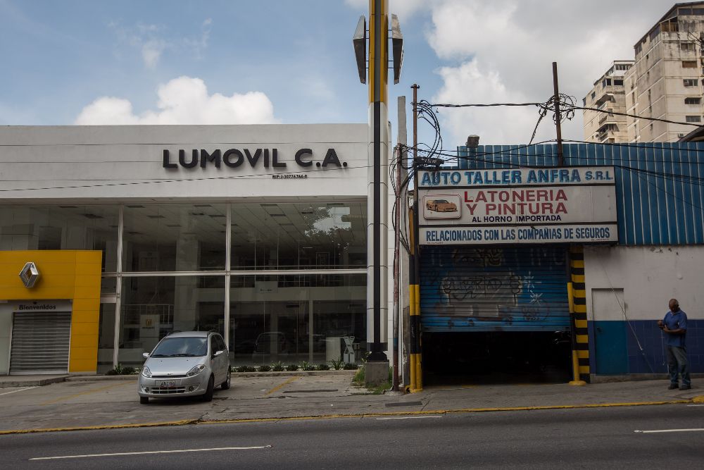 Un local comercial abierto y otro cerrado vistos hoy, viernes, 28, en Caraca. El paro general de 12 horas convocado por la oposición venezolana se cumple a medias en el país.