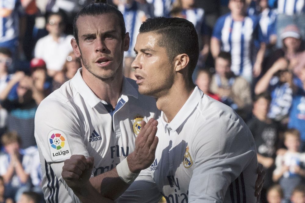 El delantero portugués del Real Madrid Cristiano Ronaldo (d) celebra con su compañero, el galés Gareth Bale, el gol marcado ante el Alavés, el primero del equipo.