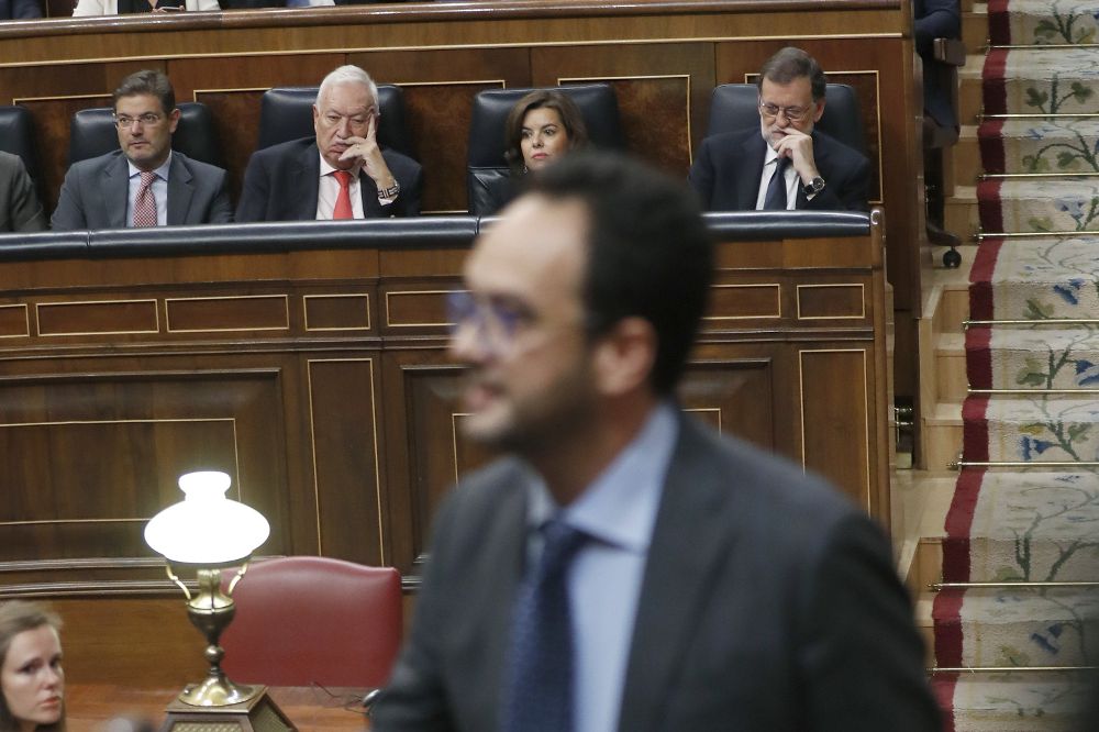 El portavoz del PSOE en el Congreso, Antonio Hernando (frente) y el líder del PP, Mariano Rajoy (atrás) durante el debate de investidura en el Congreso.