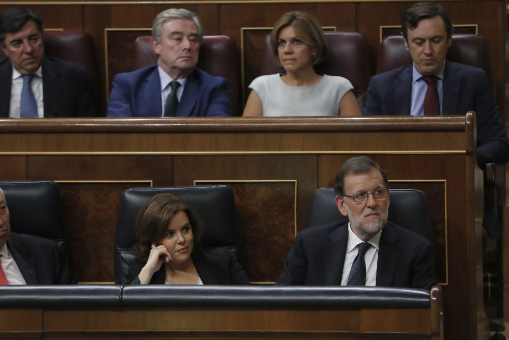 El líder del PP y presidente del Gobierno en funciones, Mariano Rajoy (d) junto a la vicepresidenta, Soraya Sáenz de Santamaría (c).