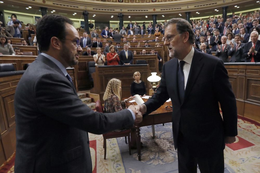 El líder del PP y presidente del Gobierno en funciones, Mariano Rajoy (d), es felicitado por el portavoz del PSOE, Antonio Hernando.