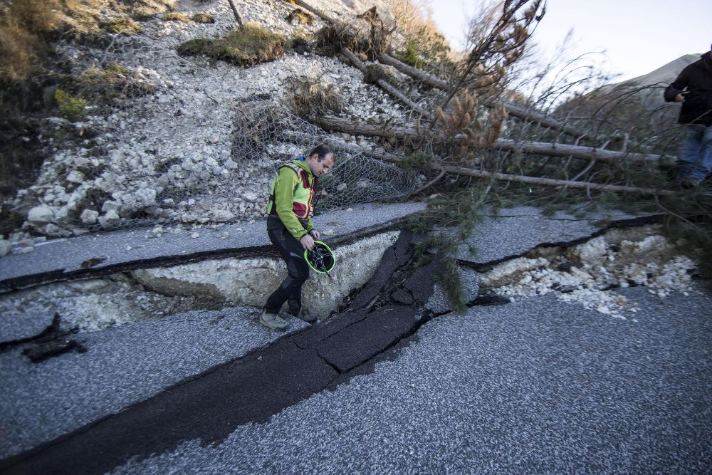 Un hombre examina una carretera dañada por el terremoto que afectó la localidad de Norcia, Italia.