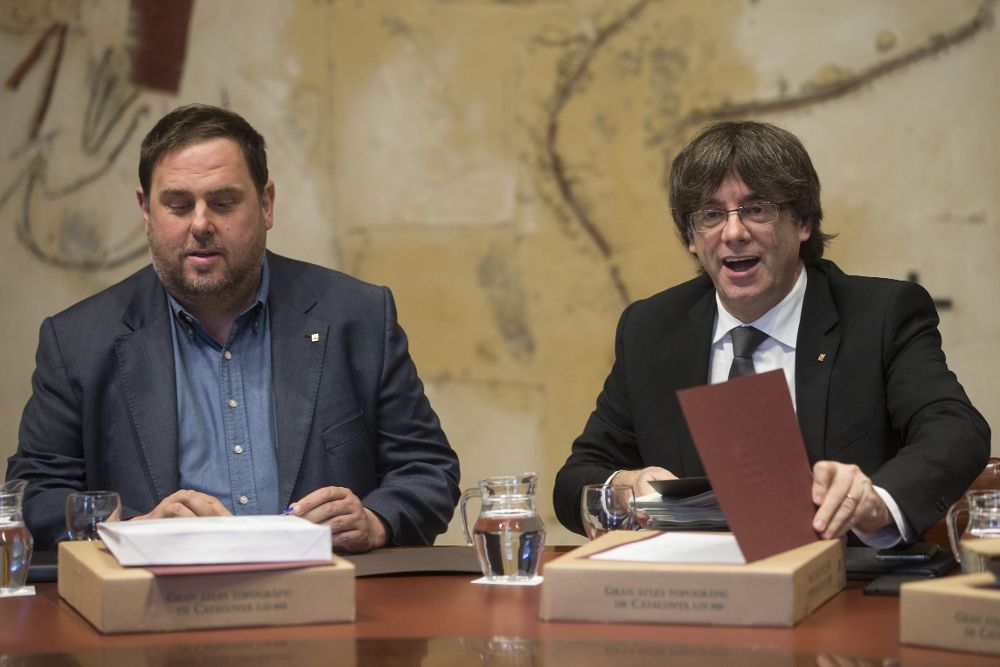 El presidente de la Generalitat, Carles Puigdemont (d), junto al vicepresidente, Oriol Junqueras, durante la reunión del Ejecutivo catalán de hoy.