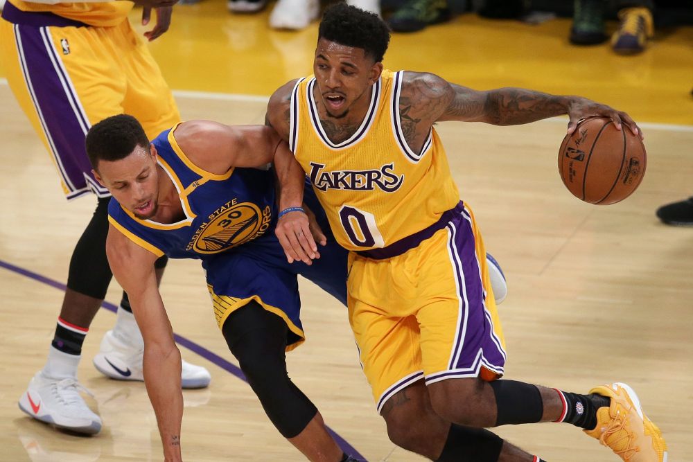 Stephen Curry (i), de Golden State Warriors, en acción contra Nick Young, de Angeles Lakers.