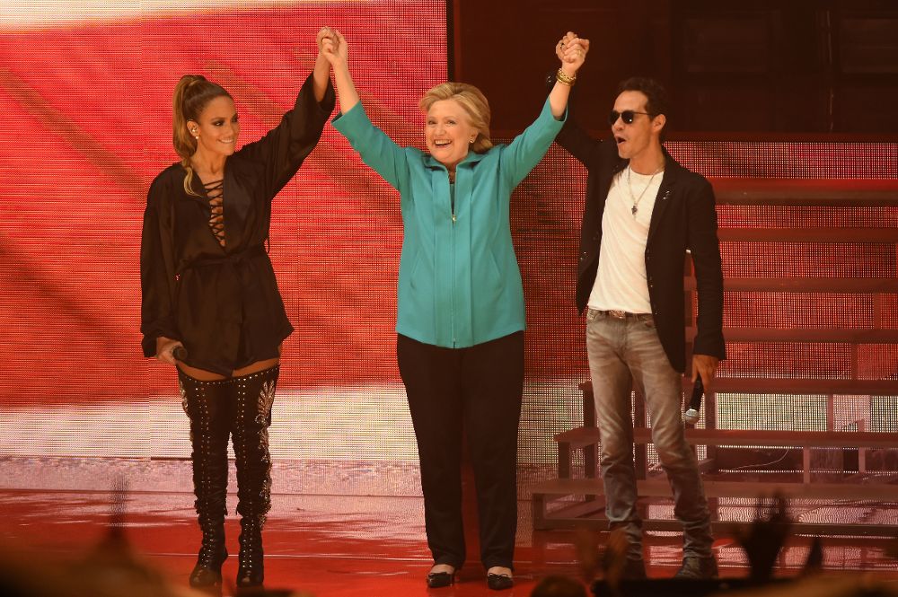 La cantante y actriz Jennifer López (i) y su exesposo, el salsero Marc Anthony (d) levantan las manos de la candidata demócrata a la Casa Blanca, Hillary Clinton (c) el sábado 29 de octubre de 2016, durante un acto de campaña en Miami.