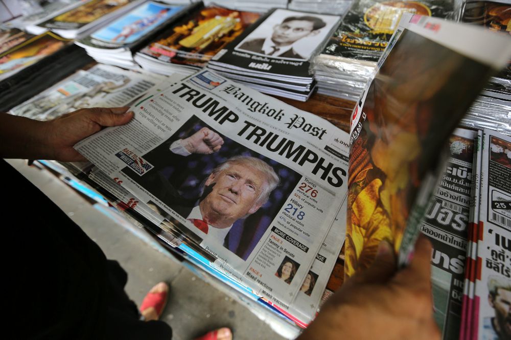 Un hombre observa un periódico en cuya portada se observa al presidente electo estadounidense, Donald Trump, hoy, 10 de noviembre de 2016, en Bangkok.
