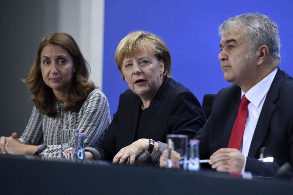 La canciller alemana Angela Merkel (C) junto con la delegada del gobierno en materia de Inmigración, Aydan Oezoguz (i) y el presidente de la Comunidad Turca de Alemania, Gökay Sofuoglu (d) durante la IX Cumbre de Integración celebrada en Berlín, Alemania ayer 14 de noviembre de 2016.