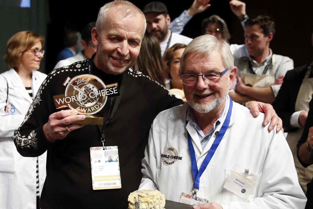El noruego Gunnar Waager (i) posa junto a un miembro del jurado internacional tras recibir el galardón al mejor queso del mundo en los World Cheese Award, por su 'Kraftkar71'.