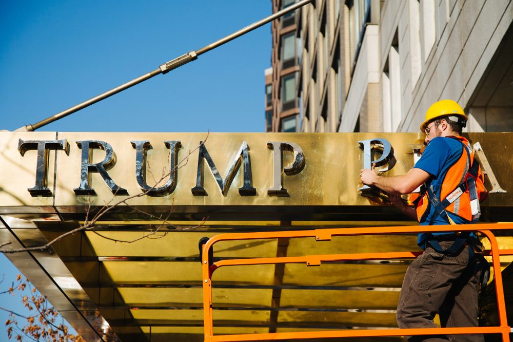Un obrero retira el nombre de "Trump Place" en la fachada de un complejo de apartamentos en Nueva York. 