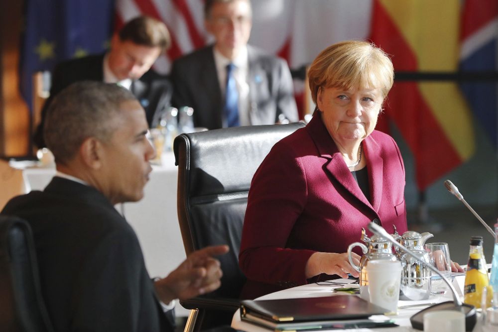 La canciller alemana, Angela Merkel (d), escucha al presidente estadounidense, Barack Obama, durante la reunión de líderes de países de la Unión Europea con Obama en Berlín.