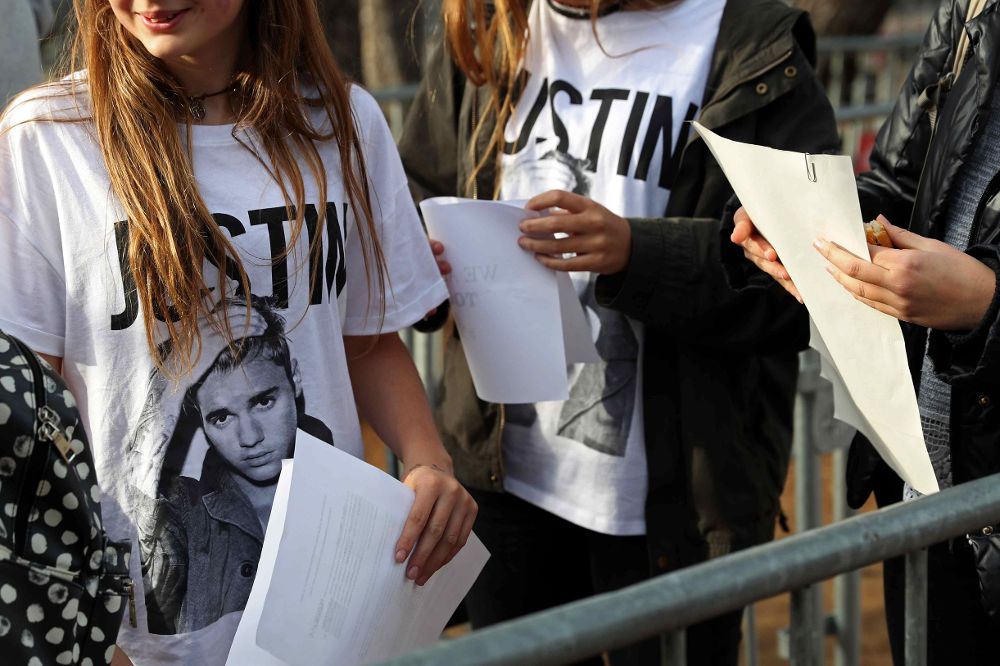 Varios fans esperan para entrar al concierto que el músico canadiense Justin Bieber en el Palau Sant Jordi de Barcelona.