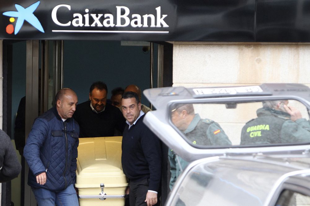 Los servicios funerarios trasladan el cadáver del director de la sucursal de La Caixa.