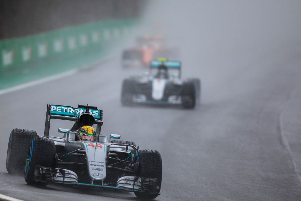 El británico Lewis Hamilton (i) y el alemán Nico Rosberg (d), de Mercedes, compiten en el Gran Premio de Brasil de Fórmula Uno.