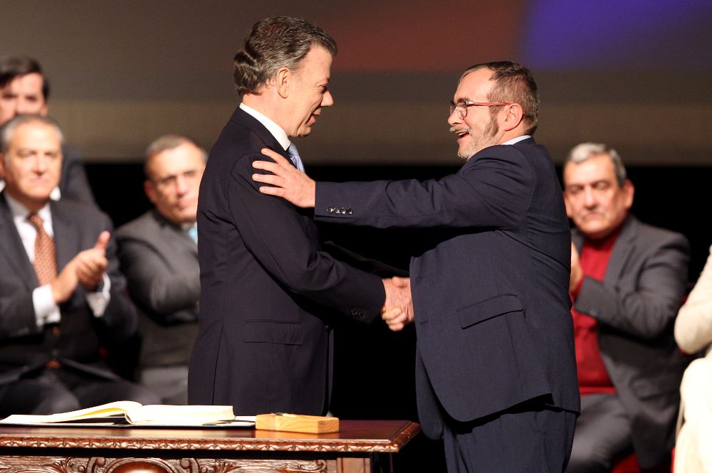 El presidente de Colombia Juan Manuel Santos (i) y el jefe máximo de las FARC, Rodrigo Londoño Echeverry se felicitan luego de firmar el nuevo acuerdo de paz.