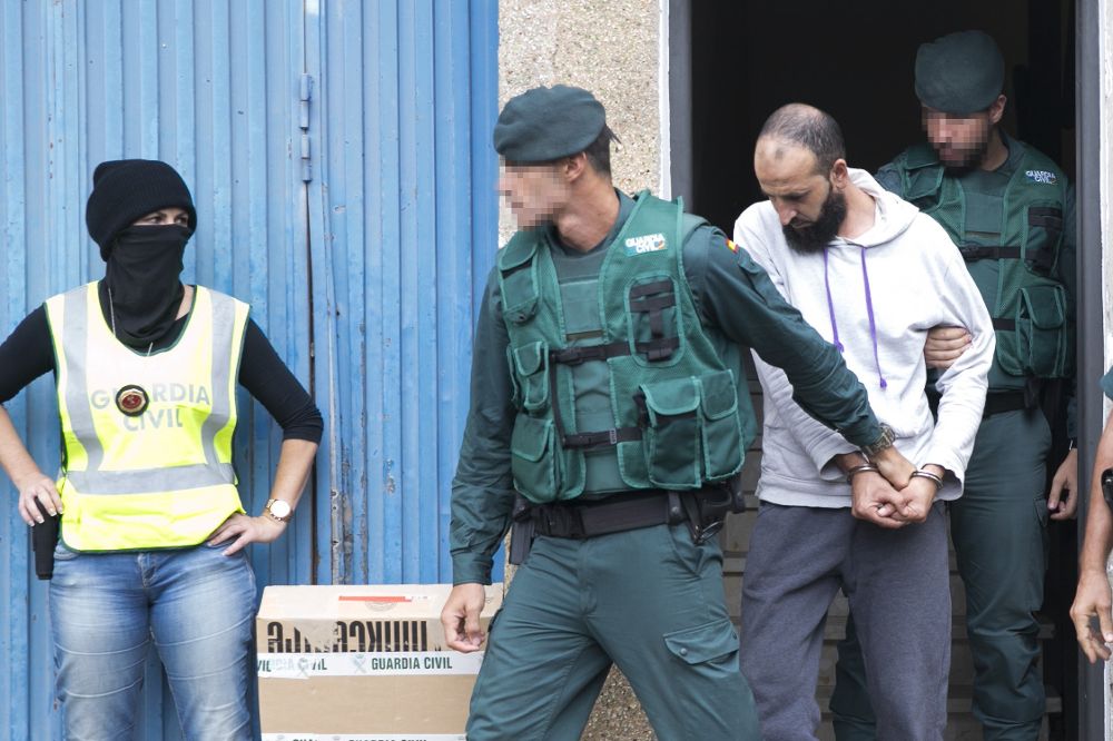 El presunto yihadista detenido hoy en el aeropuerto de Adolfo Suárez Madrid-Barajas, es trasladado por agentes de la Guardia Civil tras el registro a su vivienda en el número 16 de la calle Tinajo, en la localidad de Vecindario, en la isla de Gran Canaria. 