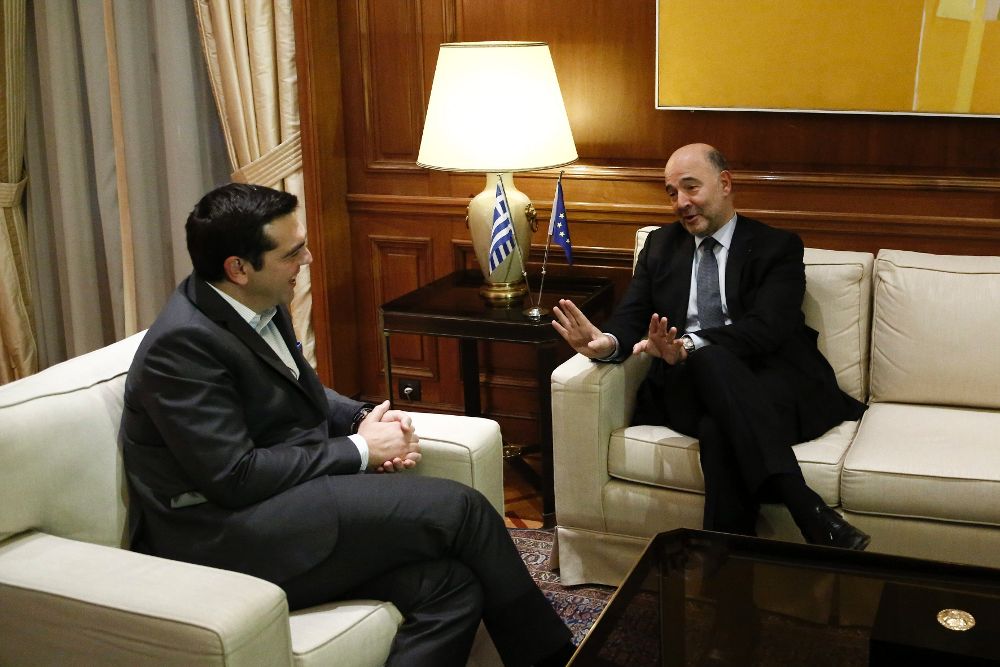 El primer ministro griego, Alexis Tsipras (i), habla con el comisario europeo de Asuntos Económicos, Pierre Moscovici, durante su encuentro en Atenas.