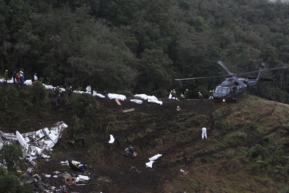 Miembros de los organismos de rescate transportan los cuerpos del avión accidentado en el municipio de La Unión, departamento de Antioquia (Colombia).
