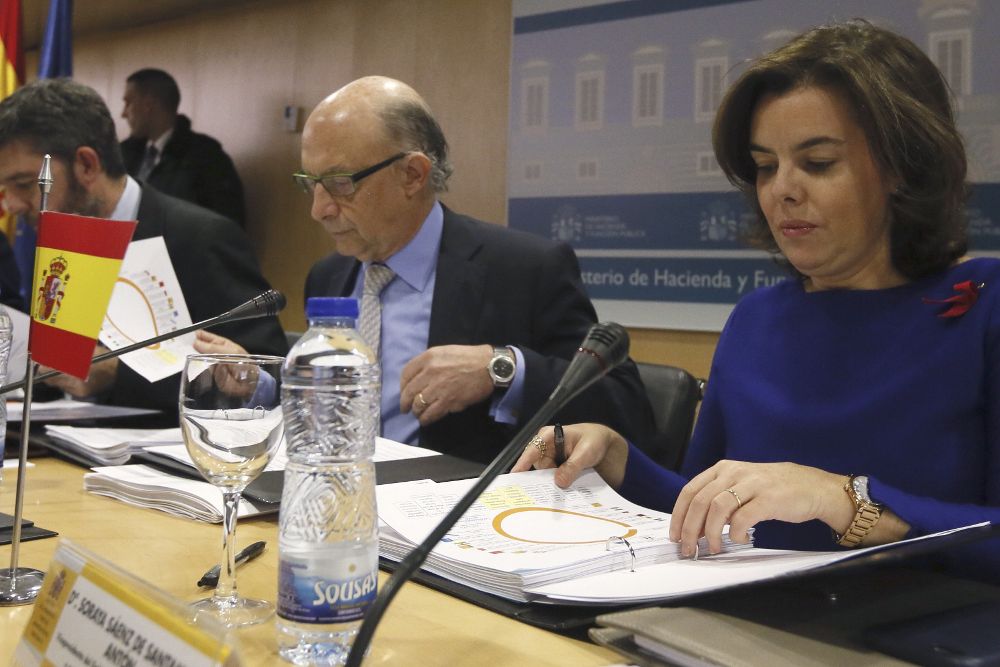 La vicepresidenta del Gobierno, Soraya Sáenz de Santamaría (d), y el ministro de Hacienda, Cristóbal Montoro (i), al inicio de la reunión del Consejo de Política Fiscal y Financiera.